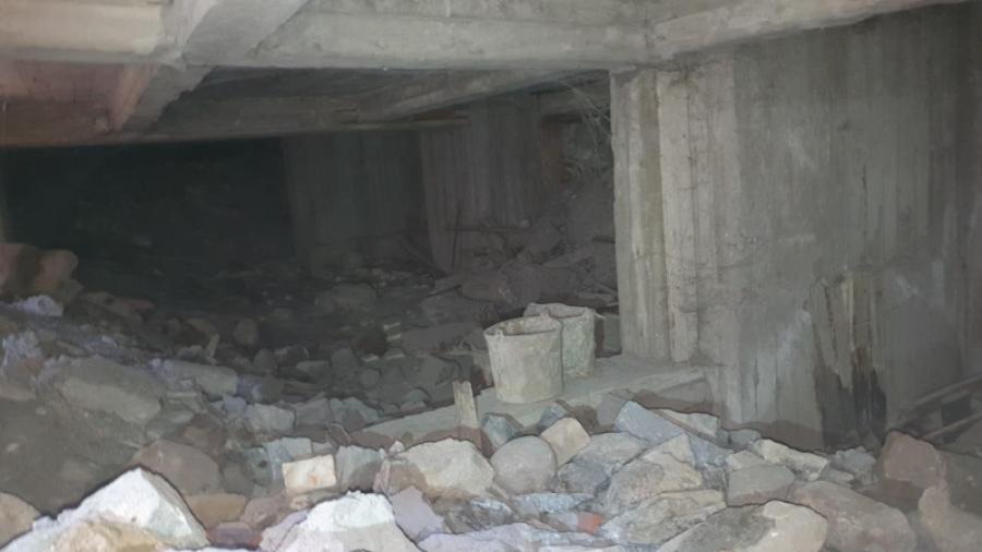 Inne under krypgrunden syns en skog av stadiga betongpelare. Överallt ligger bråte och skräp från när husets byggdes - allt överdraget med spindelväv och damm.